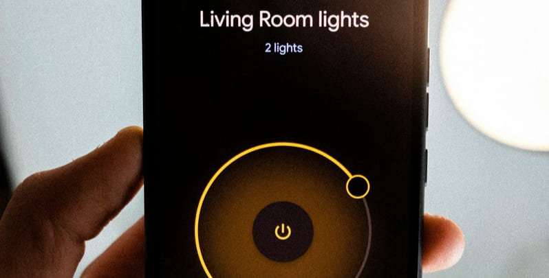 hand holding a smart phone that is operating the smart lights